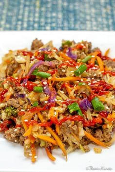 a white plate topped with meat and veggies on top of a blue table cloth