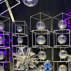 a bunch of disco balls hanging from the ceiling in front of a stage with lights