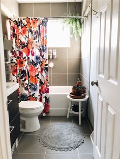 a bathroom with a shower, toilet and rug in it's center area is shown