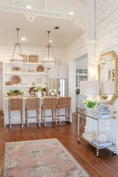 a living room filled with furniture and a large rug on top of a hard wood floor