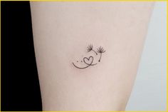 a small dandelion tattoo on the left side of the leg, with a heart in the middle