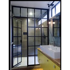 a bathroom with a sink, mirror and shower stall in the corner next to it