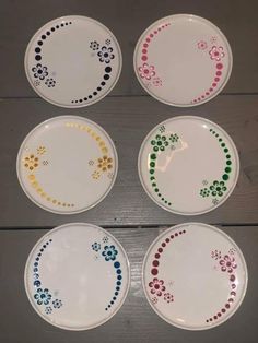 four white plates with colorful designs on them