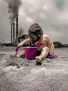 a young child in a gas mask playing in the sand