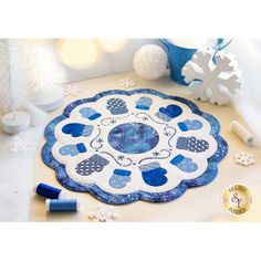 a blue and white table mat with hearts on it next to some snowflakes