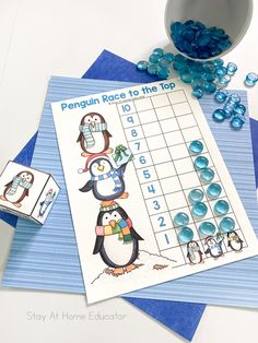 a penguin race to the top game with blue gummy candies next to it