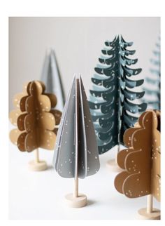 small wooden trees are lined up in the shape of christmas trees with snow on them