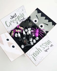 a box filled with halloween decorations on top of a white table next to a card