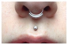 a close up of a person's nose with an open nose ring on it