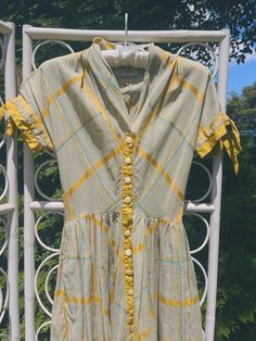 This dress was made by Carlye in the late 1940s or early 1950s. It features beautiful mustard yellow and robin's egg blue plaid -- but looks like a light greenish gray with yellow accents from a distance. It buttons up the front center. Fits similar to a modern XXS/XS. Please review measurements below. Measurements Bust: 30 inches Waist: 24 inches Length: 46 inches Condition: Excellent vintage condition. The only flaw is that the original belt, which is included, may be missing a piece. That is, I can't figure out how it is supposed to be fastened, but you might! The dress itself is pristine. If you have any questions or need additional photos or measurements, please let me know. I'm happy to help! Thank you so much for shopping with Chloris Vintage. --Chandler Retro Plaid Fitted Vintage Dress, Retro Plaid Dresses For Vintage Fashion, Fitted Retro Plaid Vintage Dress, Fitted Plaid Retro Vintage Dress, Vintage Plaid Short Sleeve Dress, Vintage Gingham Dress For Spring, Gingham Vintage Dress For Spring, Spring Vintage Gingham Dress, Fitted Plaid Vintage Dress