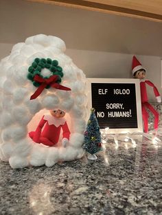 an elf is sitting in the middle of a fake snowman