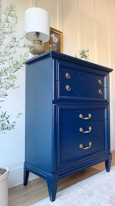 a blue dresser with gold handles in a living room