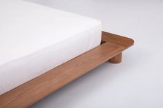 a bed with a wooden frame and white sheets