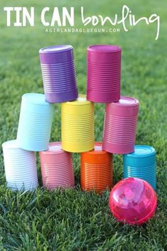 a bunch of plastic cups sitting on top of grass with the words tin can bowling