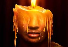 a man with icing on his face holding a lit candle in front of his face