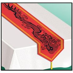 a red table runner with a dragon design on it