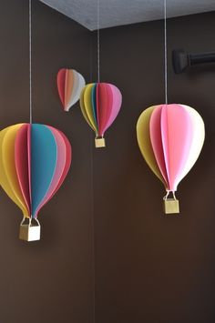 three colorful hot air balloons hanging from the ceiling