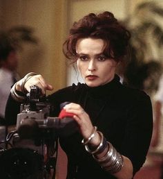 a woman holding a camera in her right hand