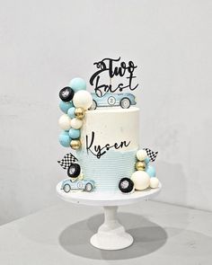 a blue and white cake with cars on it