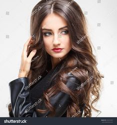 a beautiful young woman with long brown hair wearing a black leather jacket and posing for the camera