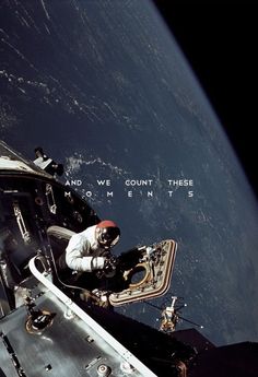 an astronaut sitting in the window of a space station looking out at the earth and writing on it