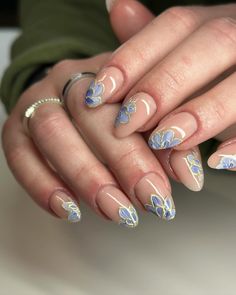 A sophisticated design featuring delicate blue petals outlined in gold on a neutral base. The intricate floral patterns add elegance and charm to the nails, making them stand out beautifully. The glossy finish and smooth oval shape complement the detailed artwork, creating a refined and stylish look.@bees.knees.nails Floral And Gold Nails, Simple Short Oval Nails, Summer Nail Patterns, Blue Floral Nails, Shellac Nails Fall, Summer Skies, Nail Types, Floral Nail Designs, October Nails