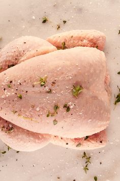 raw chicken breast with herbs and seasoning on it