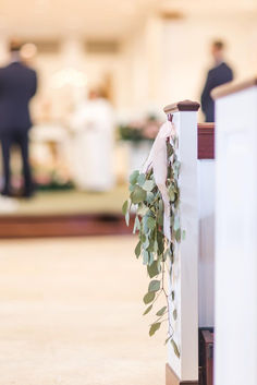 the wedding ceremony is being held at the altar with greenery hanging from it's cross