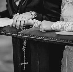 the bride and groom are holding hands while sitting at a table with their wedding rings on it