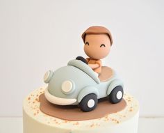 a small toy car on top of a white cake