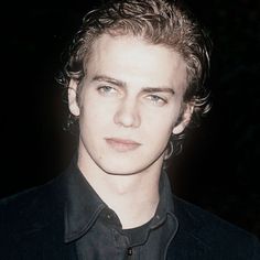 a young man with blonde hair wearing a black shirt