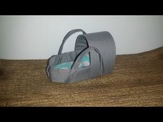 a gray bag sitting on top of a wooden table