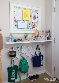 a white shelf filled with purses and other items next to a wall mounted bulletin board