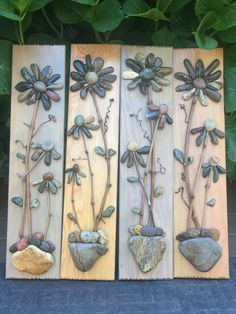 three wooden panels with flowers and rocks on them