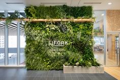 a green wall in an office with plants growing on it's sides and the words ellork above it