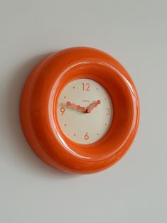 an orange and white clock on the wall