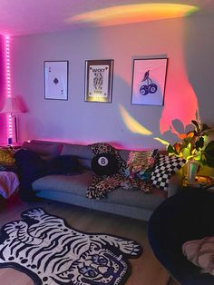 a living room filled with lots of furniture and colorful lights on the wall above it