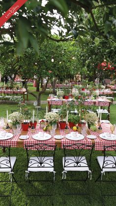 an outdoor table set up with red and white gingham cloths, plates and utensils