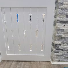 a white door with glass knobs in front of a brick wall and wood floor