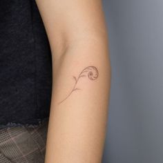 a woman's arm with a small wave tattoo on the left side of her arm