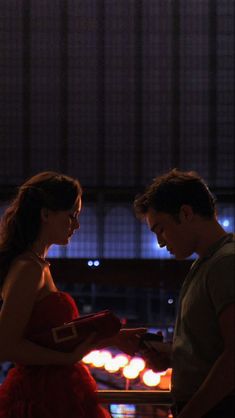 a man standing next to a woman in a red dress