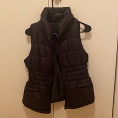 Never Worn Black Winter Vest With Pockets, Black Stretch Vest For Fall, Black Puffer Vest For Winter, Fitted Black Outerwear With Pockets, Black Stretch Outerwear For Winter, Black Fitted Casual Outerwear, Fitted Black Casual Outerwear, Fitted Black Winter Outerwear, Black Fitted Winter Outerwear