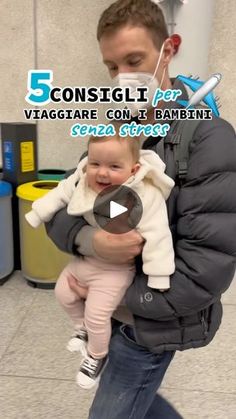 a man holding a baby in his arms with the words 5 consiglii per viagrare con un bamboonti