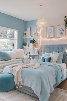 a bedroom decorated in blue and white with pictures on the wall above the headboard