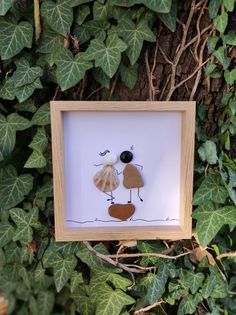 a framed picture of two birds on a tree branch with leaves around it and the frame is made out of wood