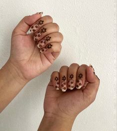 two hands with brown and white flowers on them