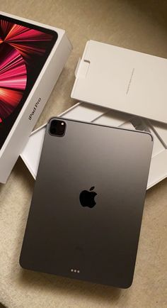 an apple ipad pro is sitting next to its box on the table in front of it