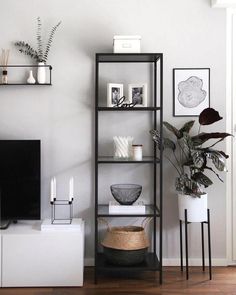 a living room filled with furniture and a flat screen tv on top of a wooden shelf