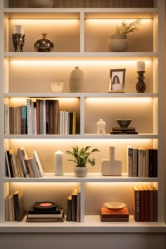 a book shelf filled with lots of books and vases on top of each other