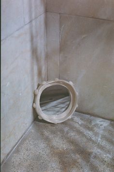 a white toilet sitting in a bathroom next to a tiled wall with a hole in it